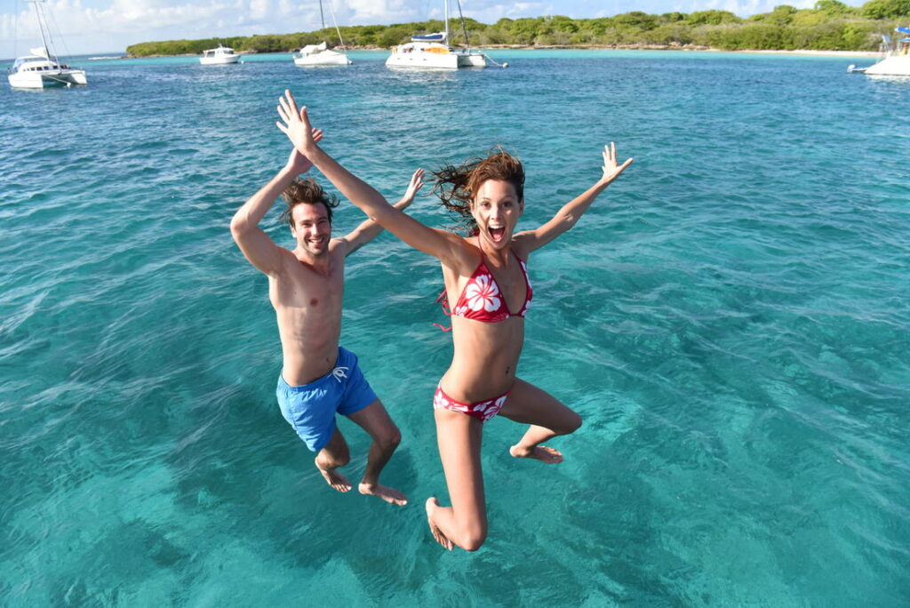 Cheerful,Couple,Jumping,Into,Water,From,Boat